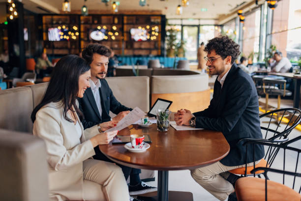 Consultants collaborating with operators around a table with plans and coffee