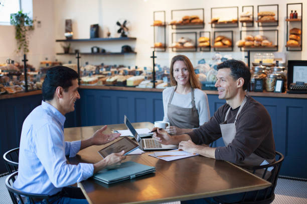 Consultants reviewing plans with café team around a wooden table